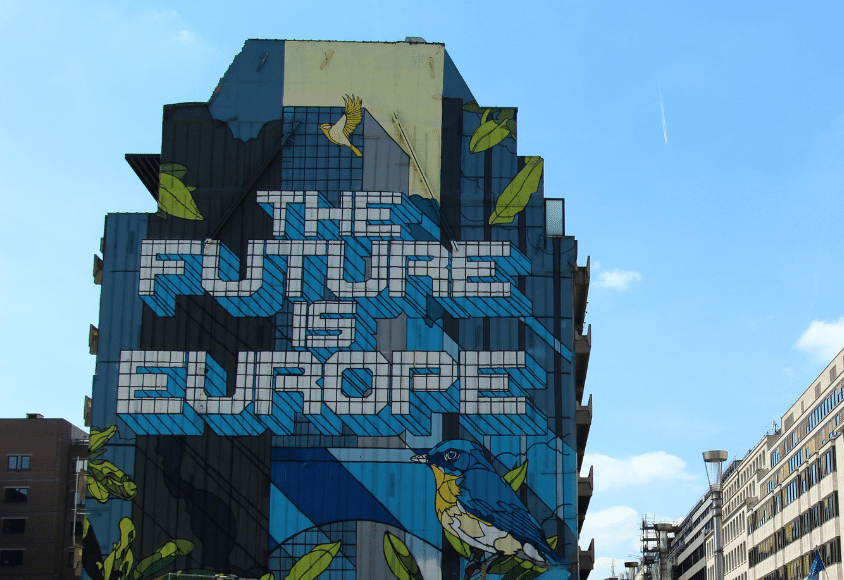 Ein Graffiti-Kunstwerk auf einer großen Hauswand stellt den Schriftzug „The future is Europe“ und zwei Vögel dar. 