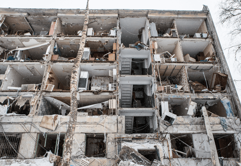 Die Außenwand des Gebäudes ist zerstört, sodass man in die ebenfalls zerstörten Wohnungen schauen kann.