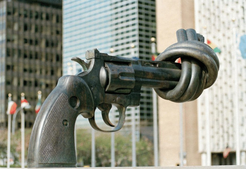 Eine Bronzeskulptur, die einen Revolver zeigt, dessen Lauf durch einen Knoten zugebunden ist.