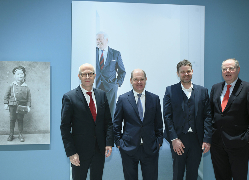 Die vier Anzugträger vor einem Bild von Helmut Schmidt.