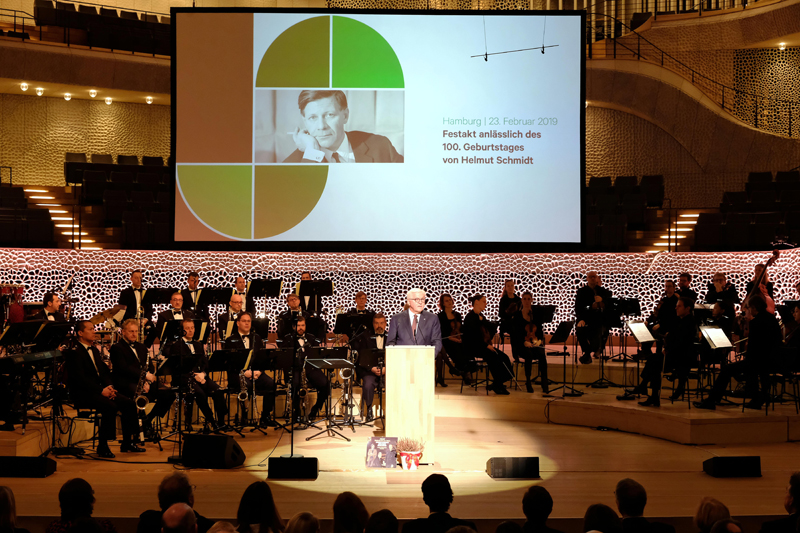 Frank-Walter Steinmeier am Rednerpult. Im Hintergrund sitzt das Orchester.