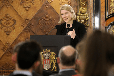 Photo of the speech of Cathryn Clüver Ashbrook r in a wood-paneled hall.