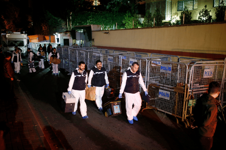 Mehrere türkische Forensiker in weißen Schutzanzügen tragen verschlossene Boxen.