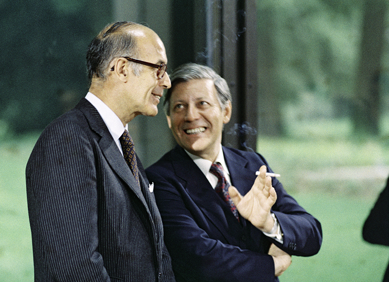 Unterhaltung zwischen Giscard d’Estaing und Helmut Schmidt. Beide lächeln.