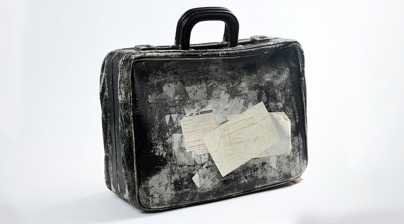 Objekt-Foto einer ledernen, schwarzen Aktentasche mit starken Gebrauchsspuren.