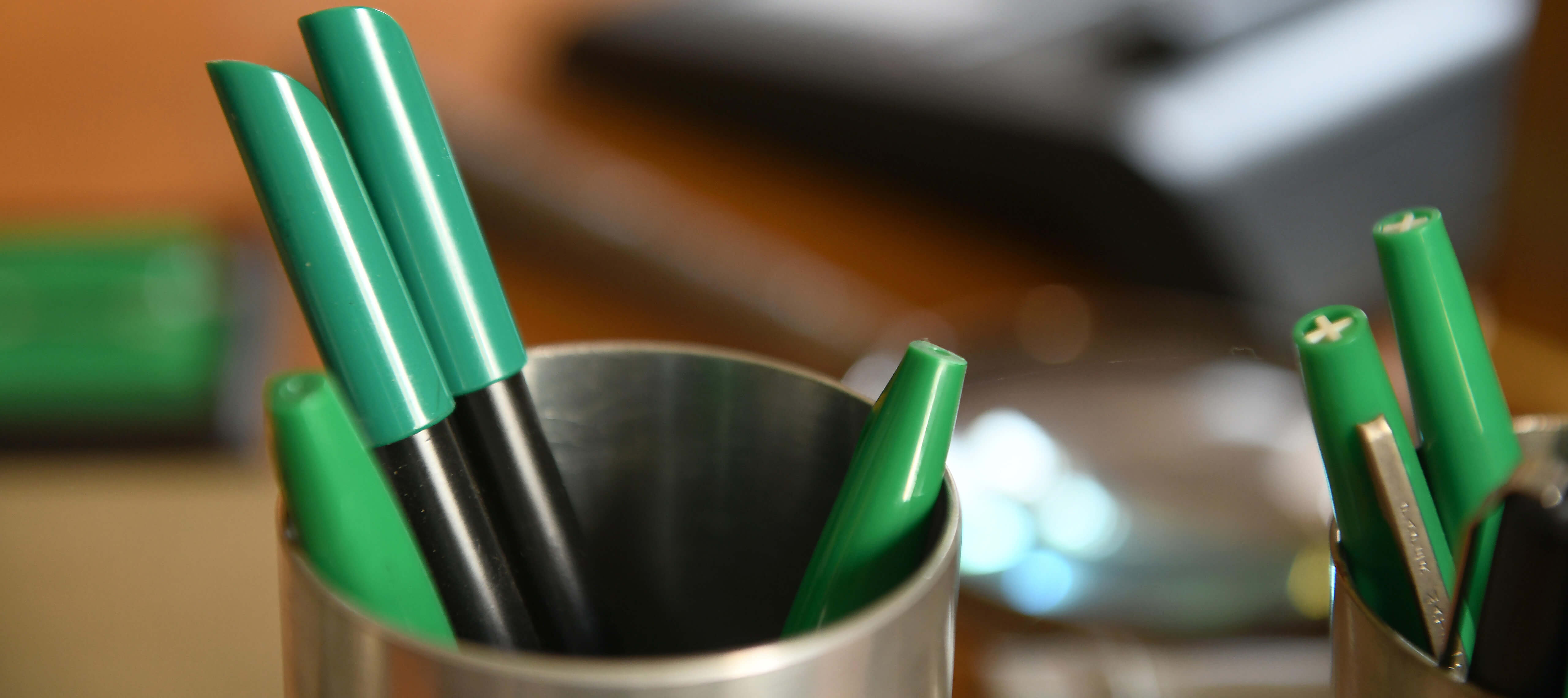 Nahaufnahme zweier Stiftbehälter mit grünen Filzmakern auf Schmidts Schreibtisch.
