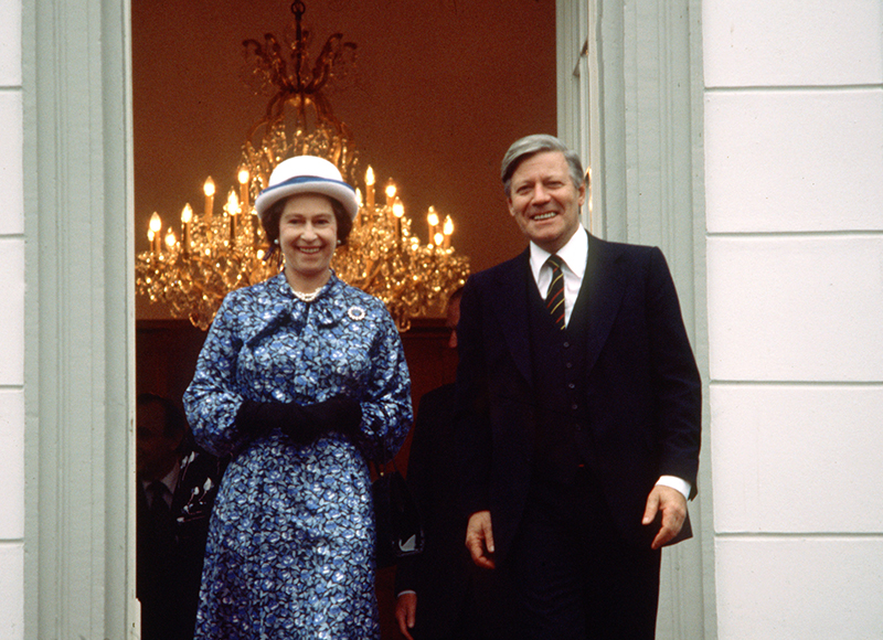 Queen Elizabeth II. und Helmut Schmidt stehen lächelnd vor dem Palais in Schaumberg in Bonn.