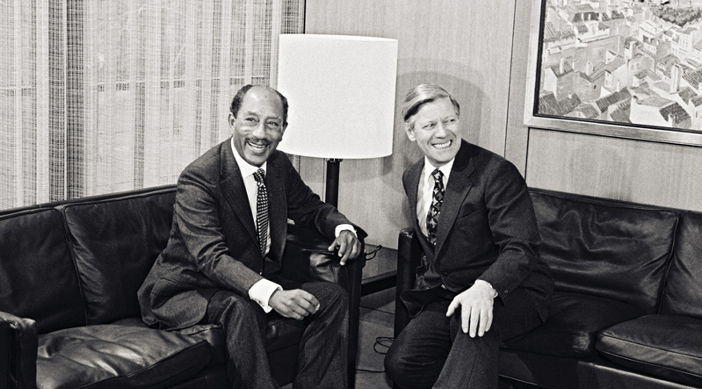Anwar as-Sadat und Helmut Schmidt sitzen auf schwarzen Ledersofas.