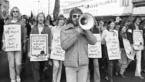 Black and white photo of demonstrators with signs and megaphone