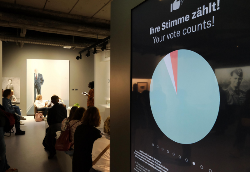 links sitzen Menschen in einer Ausstellung, rechts ein Bild einer Grafik in der Ausstellung