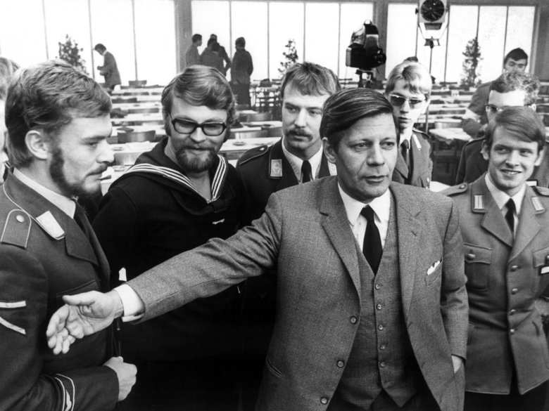 Black and white photograph of Helmut Schmidt in front of soldiers of the air force, navy and army