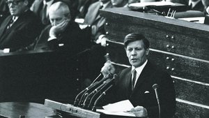 Black-and-white photograph, 1969: Helmut Schmidt is speaking at the lectern in the Bundestag, raising his finger; members of parliament are seated behind him. He is taking part in the debate on emergency legislation in the Bundestag.