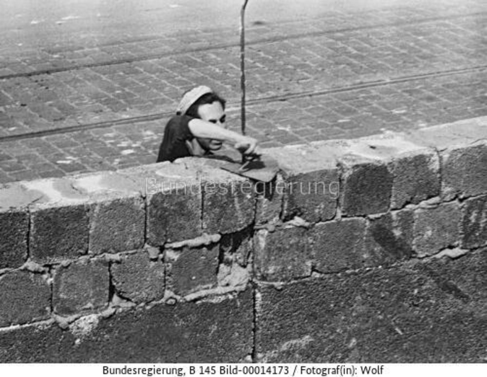 Black-and-white photograph of construction workers building a wall