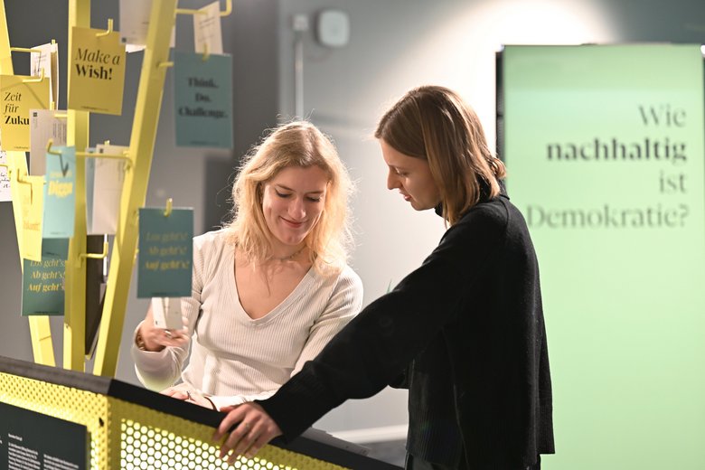 Zwei Frauen lesen einen Ausstellungs-Text