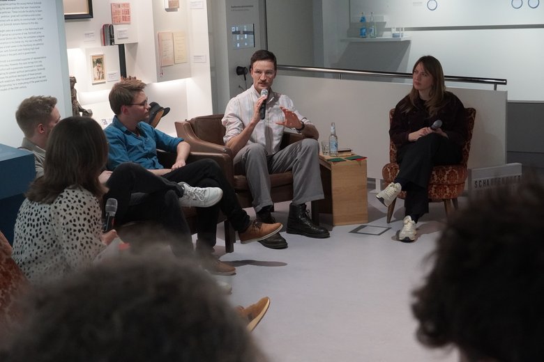 Ein Ausschnitt aus der Veranstaltung Schaufenster Demokratie. Menschen sitzen im Kreis, eine Person spricht in ein Mikrofon.