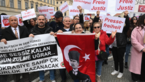 Gruppe von Demonstrierenden mit Plakaten "Freie Justiz" und "Pressefreiheit" und Flagge 