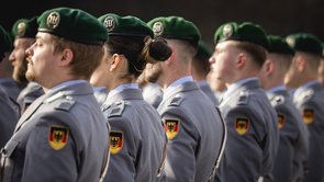 sechs Soldten in Uniform von hinten fotografiert