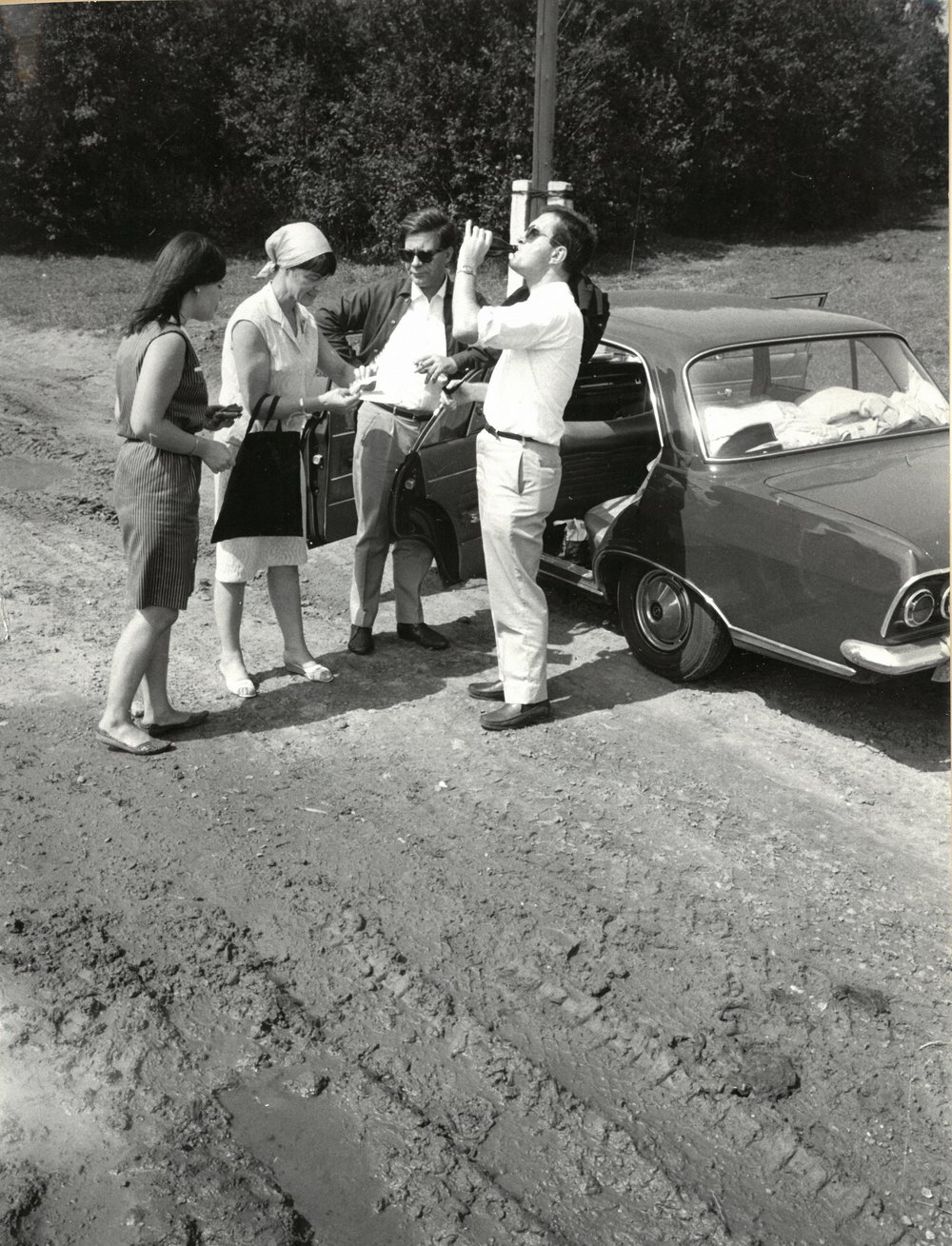 Black and white shot of Loki and Helmut Schmidt with two other people standing in front of a car