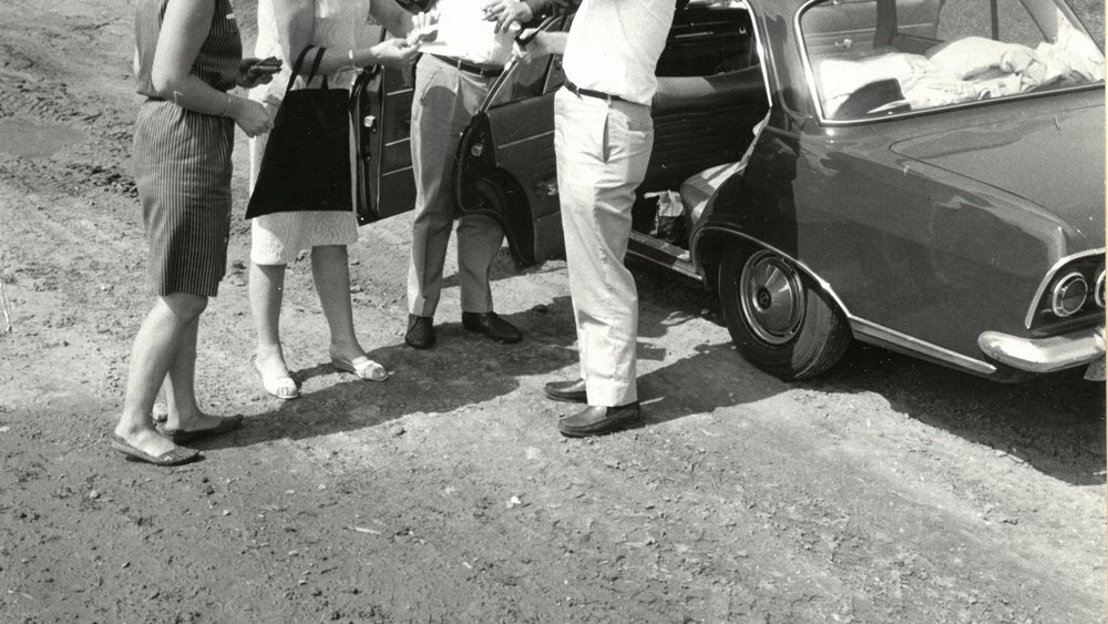Black and white shot of Loki and Helmut Schmidt with two other people standing in front of a car