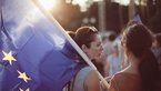 Frau von hinten mit Europäischer Flagge über Schulter