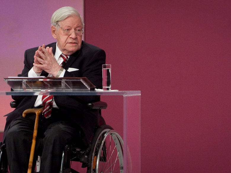 Helmut Schmidt in Rollstuhl auf Podium
