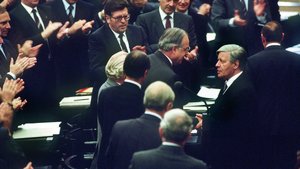 Colour photograph, 1982: Helmut Schmidt in conversation in the Bundestag, surrounded by applauding MPs; next to him is Helmut Kohl.