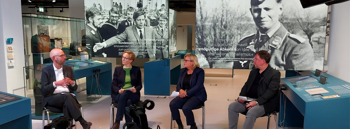 Vier Personen sitzen in der Dauerausstellung „Schmidt! Demokratie leben“ und führen ein Gespräch.