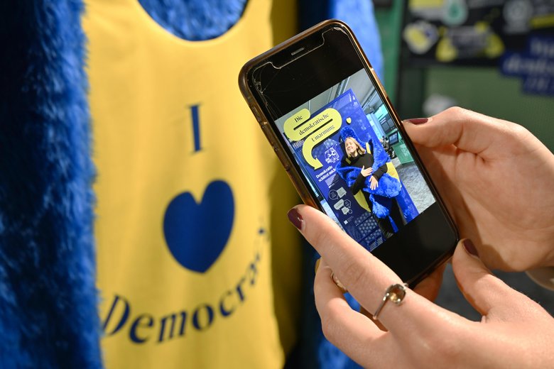 Colour photograph: a yellow and blue exhibition object with the words I love Democracy