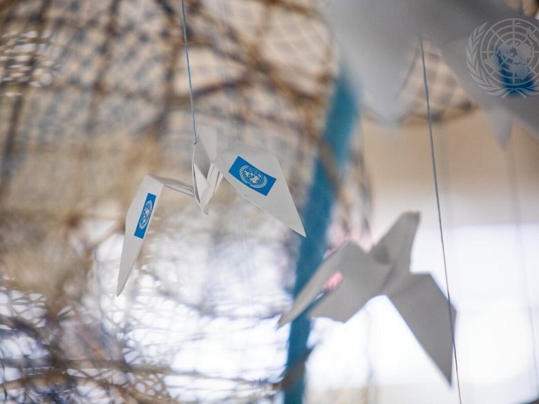 Photo of a paper aeroplane with the logo of the United Nations