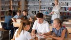 Young people sitting in groups at tables and discussing