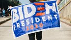 Man from behind with "Biden President" flag over his back