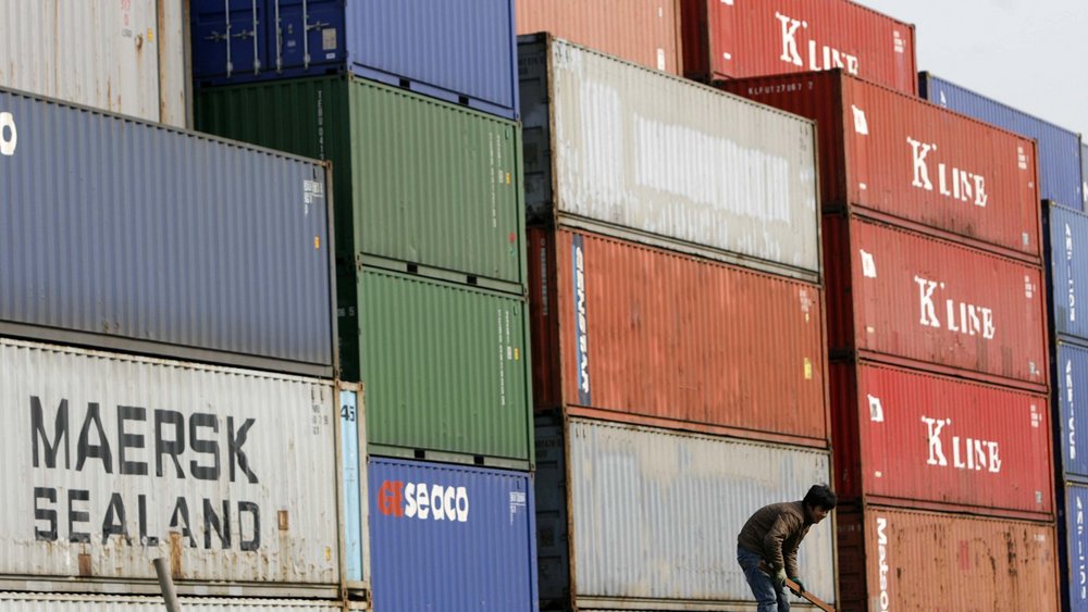 Ein Arbeiter vor Containern in einem Lagerdepot