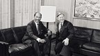 Helmut Schmidt and Anwar as-Sadat sitting on a couch and laughing