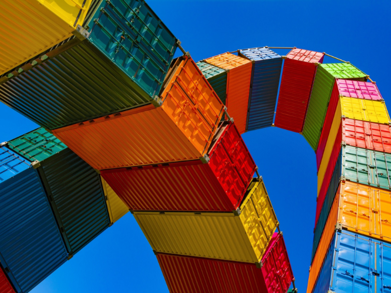 Colourful containers are stacked on top of each other and the perspective is from below.