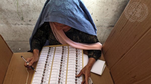 Eine Frau füllt einen Wahlzettel aus.