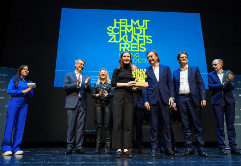 [Translate to English:] Sanna Marin gemeinsam mit den Jurymitgliedern und Aline Abboud auf der Bühne