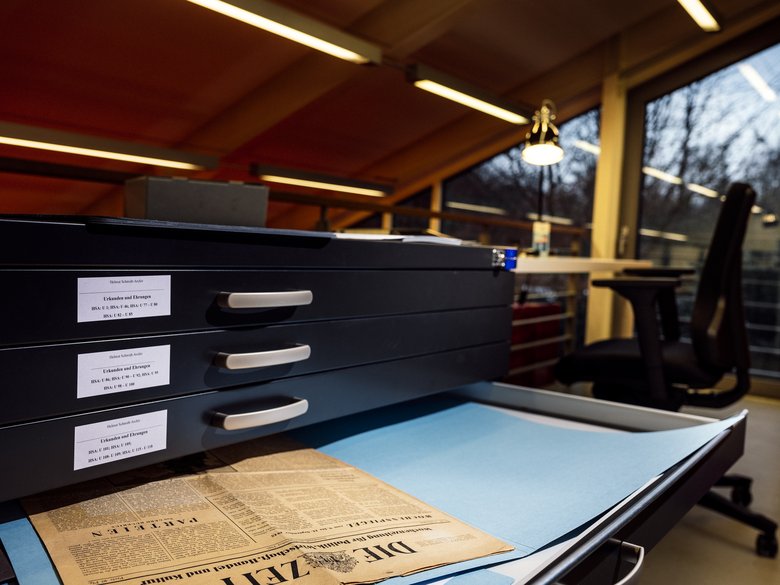 Zeitung liegt in einer geöffneten Schublade eines Archivschrankes