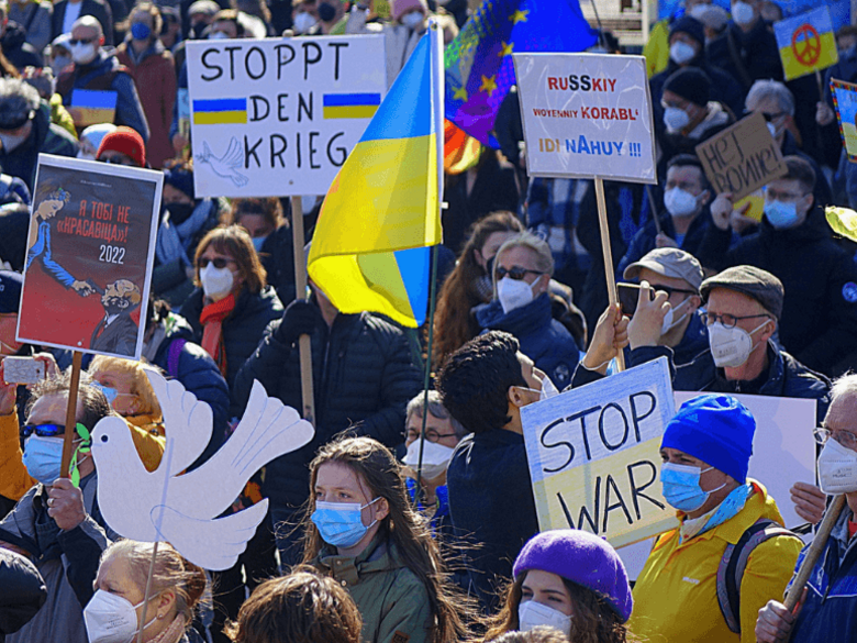 Crowd of demonstrators with Ukrainian flags and protest signs