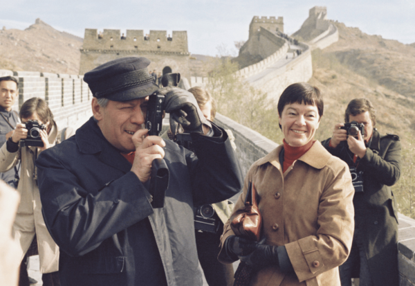 Helmut Schmidt auf der chinesischen Mauer mit einem Fotoapparat vor dem Gesicht.