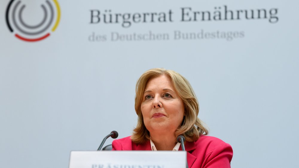 Bärbel Bas auf Podium hinter Mikrofon sitzend und Schriftzug "Bürgerrat Ernährung" im Hintergrund