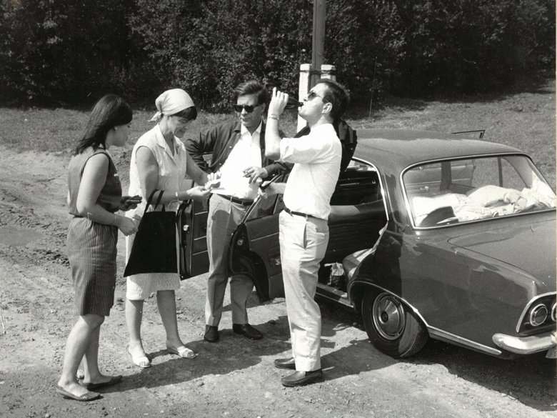 Schwarz-Weiß-Aufnahe von Loki und Helmut Schmidt mit zwei weiteren Personen vor Auto stehend