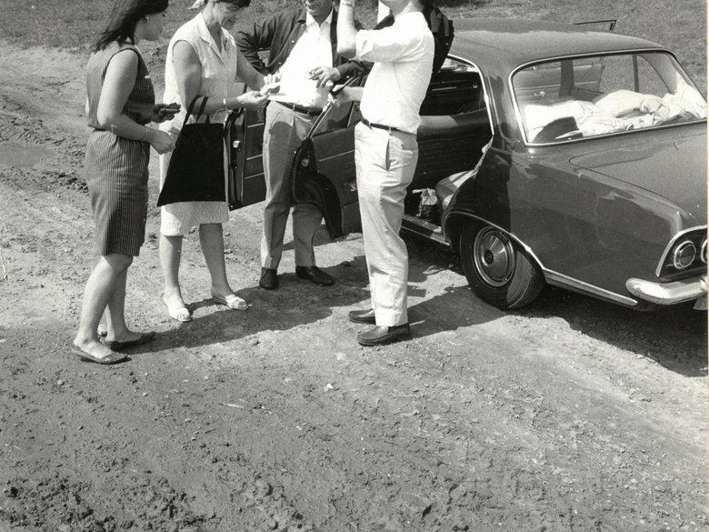 Black and white shot of Loki and Helmut Schmidt with two other people standing in front of a car
