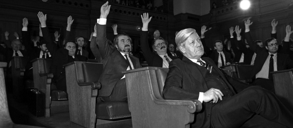 Helmut Schmidt sits in the front row of the plenary chamber of the state parliament. The majority of the SPD and CDU in the state parliament vote in favour of making him an honorary citizen. The Green Alternative List is against