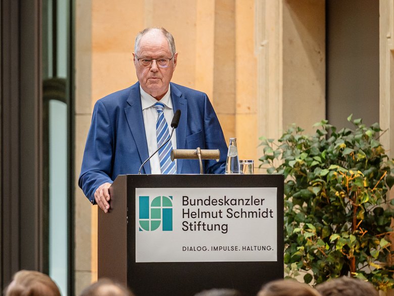 Farbfoto: Peer Steinbrück steht auf einer Bühne und begrüßt das Publikum