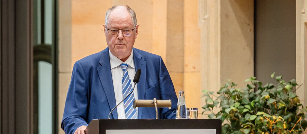 Farbfoto: Peer Steinbrück steht auf einer Bühne und begrüßt das Publikum