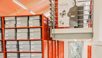 Red shelves with grey archive boxes.