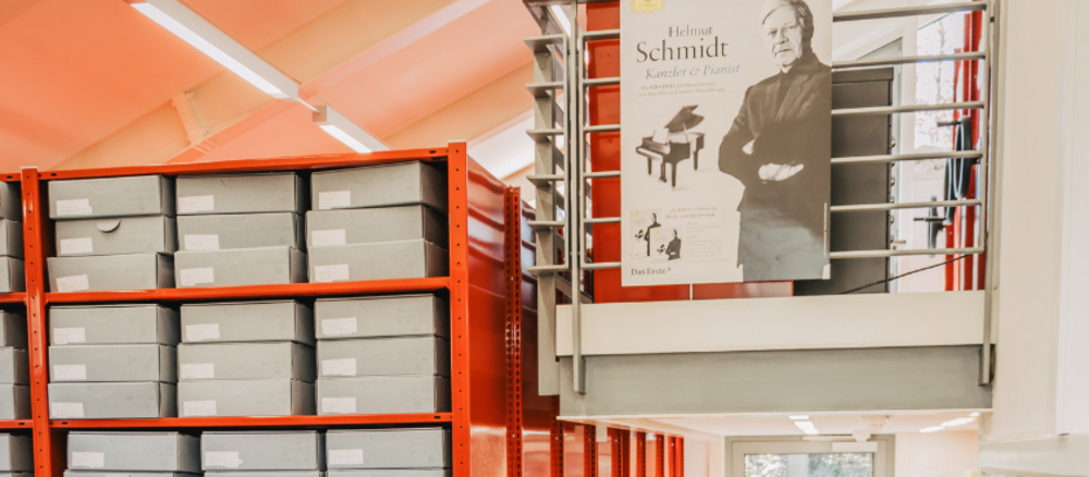 Red shelves with grey archive boxes.