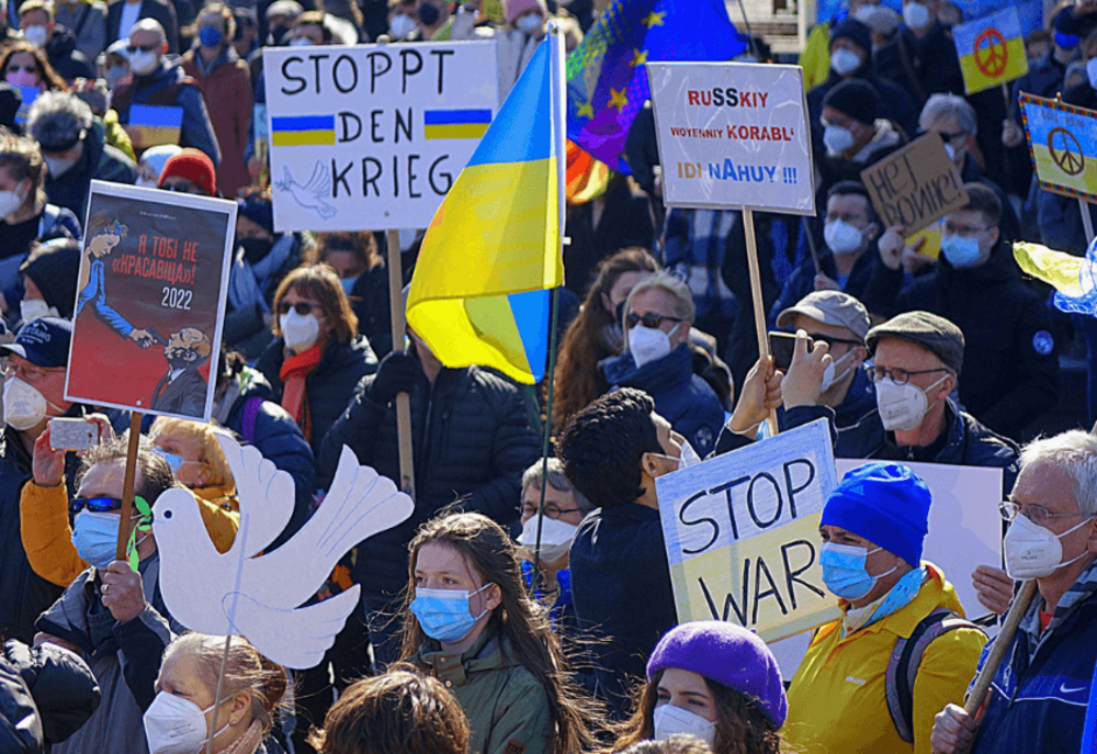 Crowd of demonstrators with Ukrainian flags and protest signs