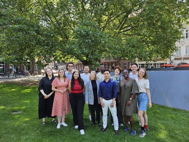 The workshop participants photographed in front of a tree.