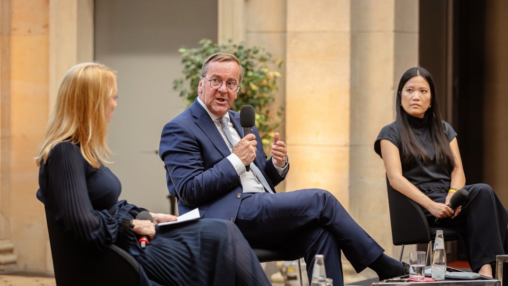 Colour photo: Melanie Amann in conversation with Boris Pistorius and Thu Nguyen (from left to right)